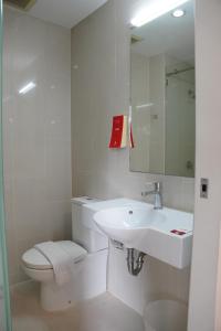 a white bathroom with a toilet and a sink at Easy Planet Pattaya in Pattaya +23 photos
