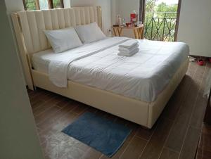 a bed in a bedroom with a blue rug at Sunset Bridge Hotel Phu Quoc in Phú Quốc