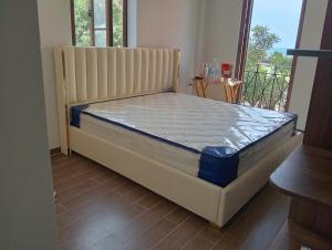 a large bed in a room with a window at Sunset Bridge Hotel Phu Quoc in Phú Quốc