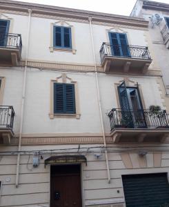 un edificio con ventanas con persianas azules y una puerta en Butterfly Apartments, en Palermo