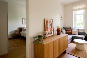 a living room with a couch and a table at Historic Karaimai Street Balcony Apartment, Trakai, Lithuania in Trakai