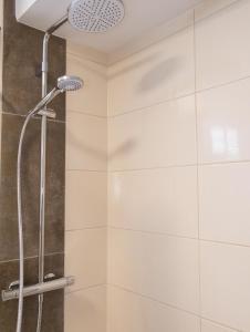 a shower with a shower head in a bathroom at Fairschlafen Boutique Hotel in Neustadt in Holstein +32 photos