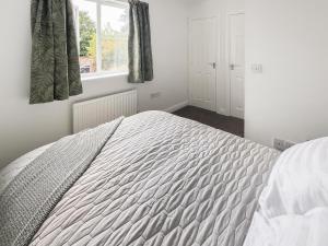 a white bed in a bedroom with a window at Ashby Meadows in Spilsby
