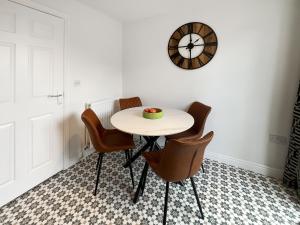 a table with chairs and a clock on the wall at Ashby Meadows in Spilsby