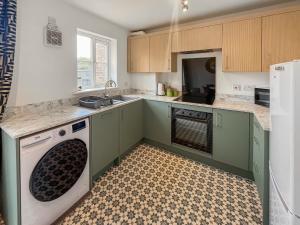 a kitchen with green cabinets and a dishwasher at Ashby Meadows in Spilsby