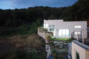 a large white house on a hill with trees at ganghwa mj hauseu in Incheon