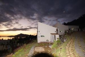 a white building on a hill with a cloudy sky at ganghwa mj hauseu in Incheon