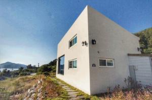 a white house sitting on top of a hill at ganghwa mj hauseu in Incheon