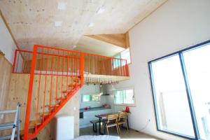 an orange staircase in a room with a table at ganghwa mj hauseu in Incheon +16 photos