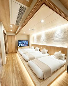 a row of beds in a room at ETSU 悦 HOTEL Chuo Ward Tokyo 1-2BDR House in Tokyo