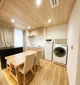 a kitchen with a table and a washer and dryer at ETSU 悦 HOTEL Chuo Ward Tokyo 1-2BDR House in Tokyo