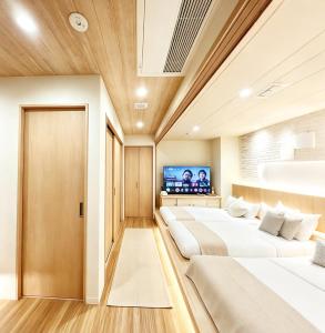a room with four beds and a flat screen tv at ETSU 悦 HOTEL Chuo Ward Tokyo 1-2BDR House in Tokyo