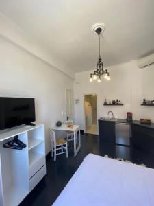 a living room with a television and a kitchen at Artelie apartment in Kyparissia