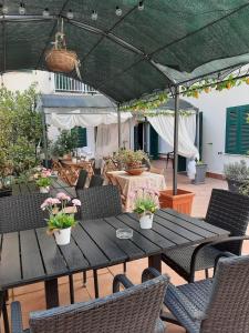 a patio with a table and chairs and a green umbrella at Alghero Sunrise in Alghero