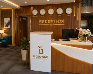 an office lobby with clocks on the wall and a reception counter at IJ Crowne in Mysore