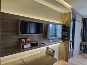 a living room with a flat screen tv on a wall at Urbitia Thonglor in Klong Toi
