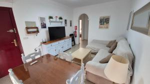 a living room with a couch and a tv at Apartamento con Garaje, WiFi, Centro y playa in Chipiona