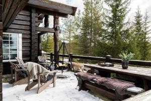 a log cabin patio with a table and chairs at Solskiva 23 in Trysil