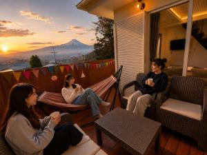 a group of women sitting in hammocks on a porch at Moro伊豆の国 in Izunokuni
