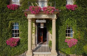 a building with a balcony with flowers on it at Angel Hotel in Bury Saint Edmunds