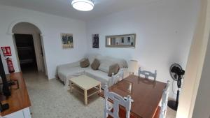 a living room with a couch and a table at Apartamento con Garaje, WiFi, Centro y playa in Chipiona