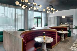a lobby with a red couch and two tables at Courtyard by Marriott Birmingham Grandview in Birmingham +17 photos