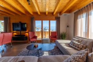 a living room with a couch and a tv at Chalet La Tirelire in Nendaz