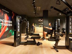 a man is sitting in a gym with weights at Pullman Lyon in Lyon