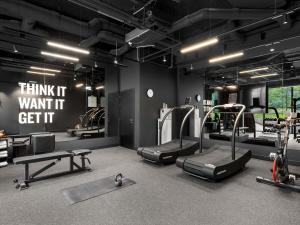 a gym with several treadmills and a sign that says think it want it at TRIBE Budapest Stadium in Budapest