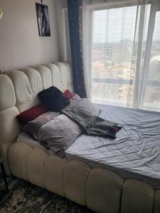 a bed with pillows on it in front of a window at Royal suburbs tsavo in Nairobi