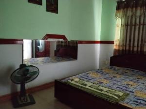 a bedroom with a bed and a mirror on the wall at Hotel Khúc Thuỵ Du in Hiệp Hòa