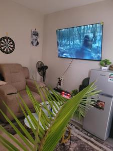 a living room with a couch and a tv on the wall at Royal suburbs tsavo in Nairobi