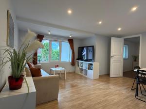 a living room with a couch and a tv at Sukkertoppen Apartment in Ålesund