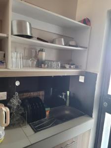 a kitchen with a sink and shelves with pots and pans at Royal suburbs tsavo in Nairobi