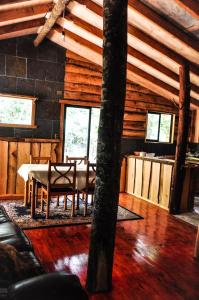 uma sala de estar com uma mesa e cadeiras num camarote em Cabaña Rustica Patagonia Chilena em Coñaripe