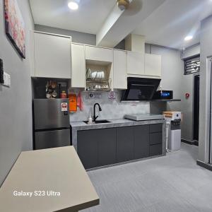 a kitchen with white cabinets and a sink at B&B By JumStay in Sepang