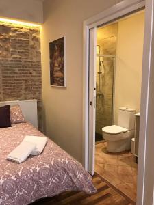 ein Schlafzimmer mit einem Bett und ein Badezimmer mit einer Toilette in der Unterkunft La Quinta Hacienda in Córdoba