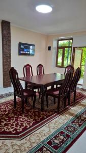 a dining room with a wooden table and chairs at Горный уют in Burchmulla