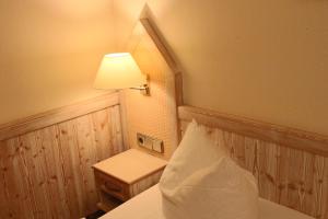 a room with a bed with a lamp and a table at Central-Hotel in Winterberg