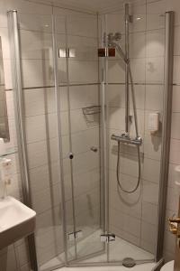 a shower with a glass door in a bathroom at Central-Hotel in Winterberg