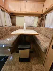 a table and bench in a tiny house at Full Service Caravan 2 in Gentofte
