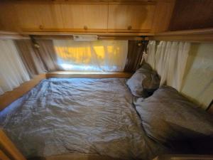 a small bed in the back of a tent at Full Service Caravan 2 in Gentofte