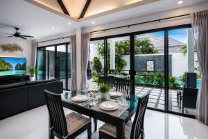 a dining room with a table and chairs at Pool Villa Clos Vougeot Tropical Vibe in Ban Saiyuan (1)