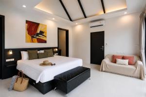 a bedroom with a large bed and a couch at Pool Villa Clos Vougeot Tropical Vibe in Ban Saiyuan (1)