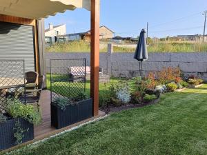 a garden with a patio with an umbrella at Cabañita Playa Espiñeiro in A Lanzada