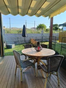 a wooden table and chairs on a wooden deck at Cabañita Playa Espiñeiro in A Lanzada