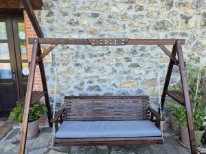 a wooden swing in front of a stone wall at El Conventu del Asturcon in Lago