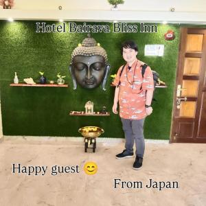 a young boy standing in front of a giant head at Bairava Bliss Inn - Rameswaram in Rāmeswaram