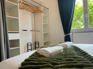 a bedroom with a bed with towels and a refrigerator at L'Appart' in Bruz