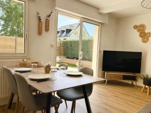 a dining room with a table and a television at L'Appart' in Bruz